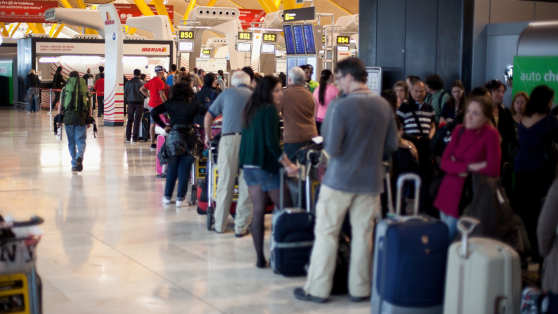 La gente hace cola en el mostrador de Iberia para modificar sus intinerarios después de que los vuelos fueran cancelados durante la huelga general en el aeropuerto de Barajas, el 29 de marzo de 2012 en Madrid, España. Los trabajadores españoles protagonizaron una huelga general para protestar contra la nueva reforma laboral del Gobierno. (Foto de Pablo Blazquez Dominguez/Getty Images)