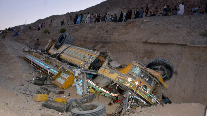 Varios lugareños se reúnen cerca de los restos de un autobús que cayó por un barranco cerca de Quetta, capital de la provincia de Baluchistán, Pakistán, el 3 de octubre de 2024. (Arshad Butt/Foto AP). 