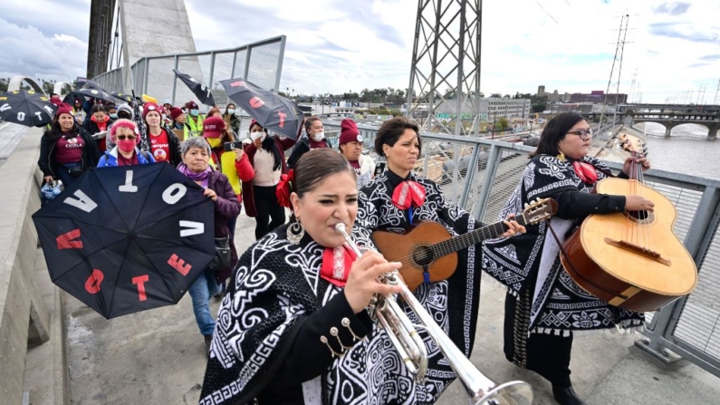 Una banda de mariachis guía a un grupo de votantes latinos e inmigrantes a través del puente del Viaducto de la Calle 6 hacia un centro de votación durante las elecciones intermedias de Estados Unidos el 8 de noviembre de 2022 en Los Ángeles, California.(FREDERIC J. BROWN/AFP via Getty Images)