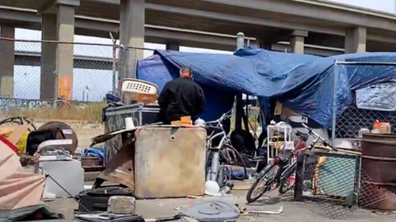 Una persona frente a un campamento de personas sin hogar bajo la I-880 en Oakland, California, el 26 de mayo de 2022. (Cynthia Cai/NTD Televisión)