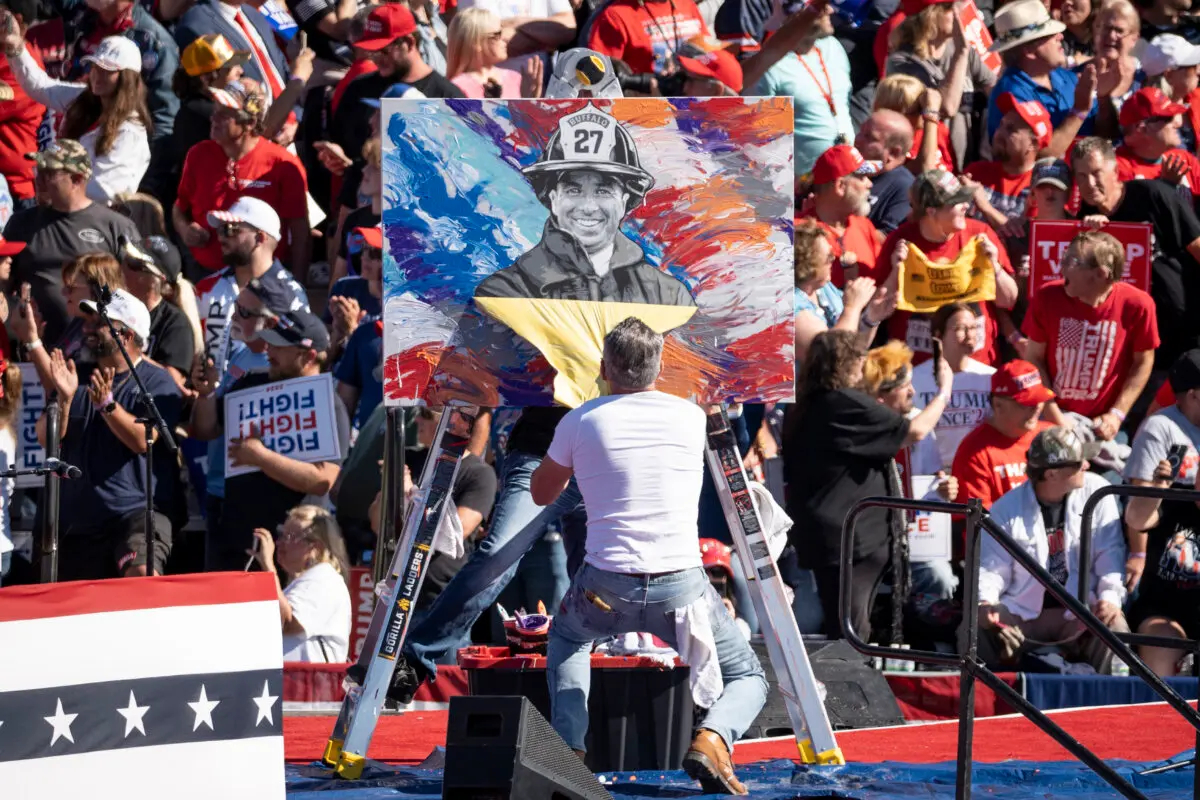 El artista Scott Lobaido desvela su obra de arte de Corey Comperatore en un mitin con el expresidente Donald J. Trump en Butler Farm Show en Butler, Pensilvania, el 5 de octubre de 2024. (Samira Bouaou/The Epoch Times)