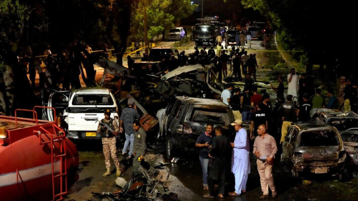 Funcionarios de seguridad examinan el lugar de una explosión que causó lesiones y destruyó vehículos en las afueras del aeropuerto de Karachi, Pakistán, la madrugada del 7 de octubre de 2024. (Fareed Khan/AP Photo)