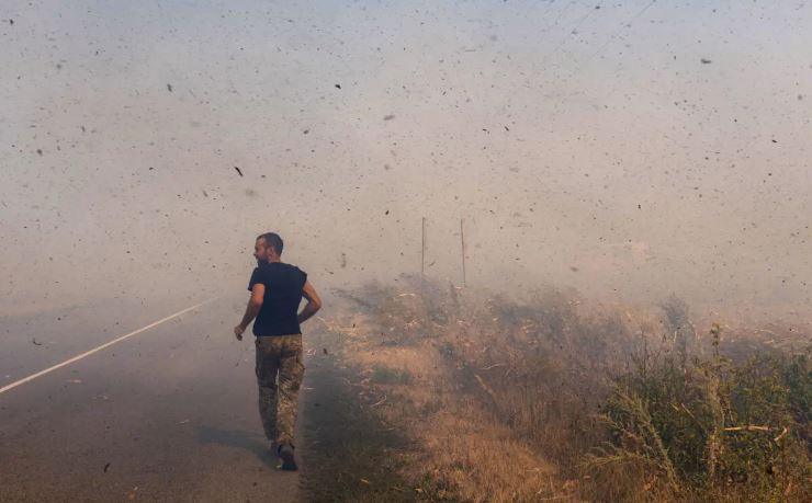 Un militar ucraniano corre para ayudar a los agricultores a extinguir un campo en llamas cerca de Pokrovsk, región de Donetsk, Ucrania, el 16 de septiembre de 2024. (Oleksii Filippov/AFP vía Getty Images)