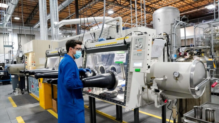 El ingeniero de pruebas Jacob Wilcox saca su brazo de una caja de guantes utilizada para procesar sodio en TerraPower, una empresa que desarrolla y construye pequeños reactores nucleares el 13 de enero de 2022, en Everett, Wash. (AP Photo/Elaine Thompson, Archivo). 