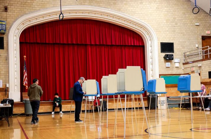 Votantes depositan sus papeletas durante las primarias presidenciales de Michigan en un colegio electoral de Dearborn, Michigan, el 27 de febrero de 2024. (Jeff Kowalsky/AFP vía Getty Images)