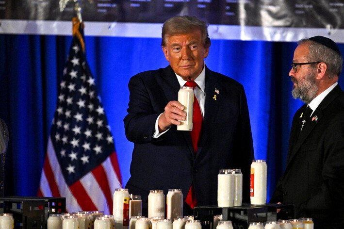 El expresidente estadounidense y candidato presidencial republicano Donald Trump sostiene una vela en un evento que conmemora el primer aniversario del ataque de Hamas a Israel, en el club de golf Trump National Doral en Miami, Florida, el 7 de octubre de 2024. (Chandan Khanna/AFP)