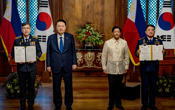 El presidente filipino Ferdinand Marcos Jr. (2.º por la derecha) y el presidente surcoreano Yoon Suk Yeol (2.º por la izquierda) posan para fotografías mientras Kim Jong-uk (izq.), comisionado general de la guardia costera coreana, y Ronnie Gil Gavan, comandante de la guardia costera filipina, sostienen acuerdos firmados durante una reunión en el Palacio de Malacañang, en Manila, Filipinas, el 7 de octubre de 2024. Yoon se encuentra en Filipinas en una visita diplomática a los socios de la ASEAN. (Ezra Acayan/Getty Images)