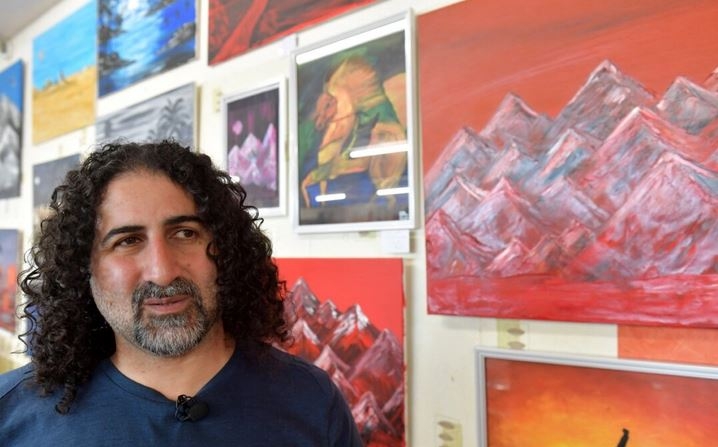 El pintor saudí Omar bin Laden, cuarto hijo mayor del exlíder de Al-Qaeda, Osama Bin Laden, posa durante una exposición de unas 30 de sus obras de arte en el «Arielle Brocante» de Le Teilleul, Francia, el 1 de julio de 2022. (Jean-Francois Monier/AFP vía Getty Images)