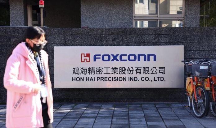 Una mujer camina junto al cartel de Foxconn fuera del edificio de la compañía en la ciudad de Nuevo Taipei, Taiwán, el 22 de diciembre de 2022. (Annabelle Chih/Reuters)