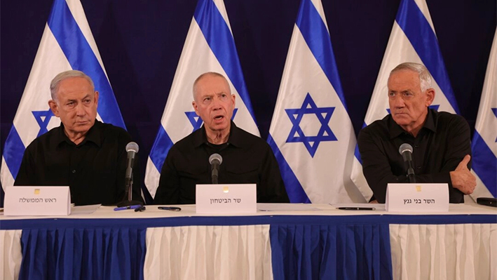 El primer ministro israelí Benjamin Netanyahu (izq.), el ministro de Defensa Yoav Gallant (segundo izq.) y el entonces ministro del Gabinete Benny Gantz (der.) hablan durante una rueda de prensa en la base militar de Kirya en Tel Aviv, Israel, el 28 de octubre de 2023. (Abir Sultan/AP)