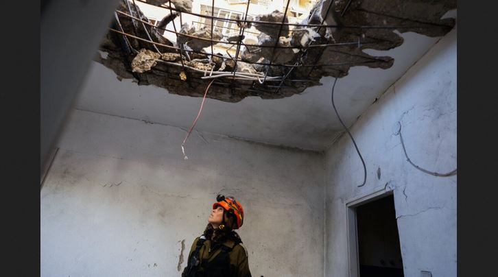 Un miembro de los servicios de emergencia israelíes inspecciona un edificio dañado por el impacto de un cohete lanzado desde Líbano, en Kiryat Yam, cerca de la ciudad de Haifa, en el norte de Israel, el 8 de octubre de 2024. El grupo militante libanés Hezbolá dijo que había lanzado una «gran salva de cohetes» contra Haifa y sus suburbios del norte el 8 de octubre, después de que el ejército israelí informara del cruce de 85 proyectiles desde Líbano. (Jack Guez/AFP vía Getty Images)