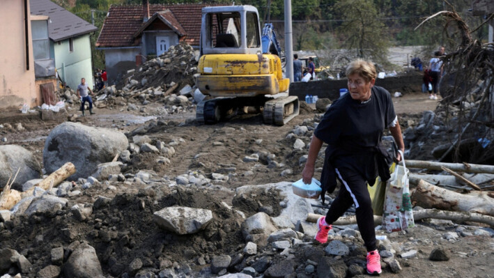 Un residente local lleva comida para los trabajadores en una zona residencial inundada en Zlate, Bosnia y Herzegovina, el 7 de octubre de 2024. (Amel Emric/Reuters)