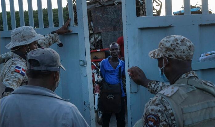 Soldados dominicanos cierran una puerta fronteriza a un hombre haitiano que esperaba cruzar a Dajabón, República Dominicana, el 19 de noviembre de 2021. (Matias Delacroix/Foto AP)