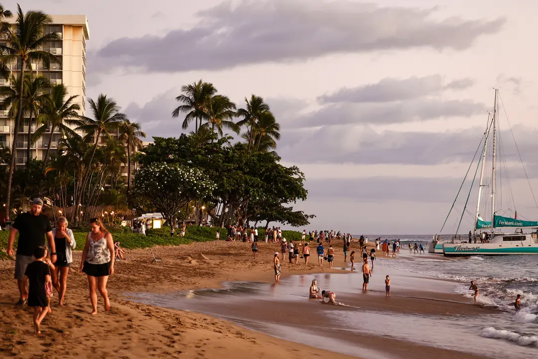 Varias personas se reúnen en la playa de Kaanapali, un popular destino turístico, cerca de Lahaina, Hawái, el 5 de agosto de 2024. (Mario Tama/Getty Images)