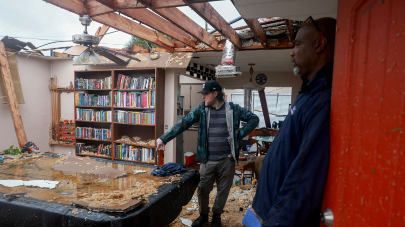 Connor Ferran (I) y su vecino Leroy Roker examinan lo que queda después de que, lo que parecía ser un tornado, arrancó el techo de la casa de Ferran antes de la llegada del huracán Milton el 09 de octubre de 2024, en Fort Myers, Florida. (Joe Raedle/Getty Images)