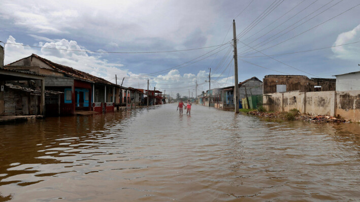  Personas caminan por una calle afectada por las inundaciones tras el paso del huracán Milton hacia Florida este miércoles, en Batabanó, Cuba.  (EE.UU.). EFE/ Ernesto Mastrascusa