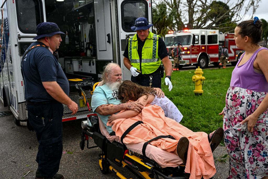 Alexa Haight abraza a su abuelo Robin Haight antes de ser llevado al hospital por los médicos después de resultar herido por un tornado que golpeó su casa en Fort Myers, Florida, el 9 de octubre de 2024, mientras el huracán Milton se acerca. Chandan Khanna/AFP vía Getty Images)