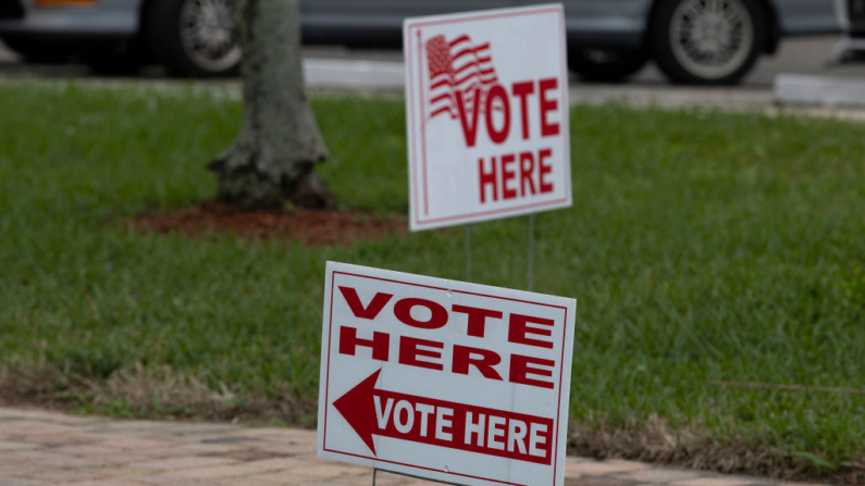 Carteles en el exterior de un colegio electoral durante las elecciones al Congreso del distrito 20 en Lauderhill, Florida, el 11 de enero de 2022. (Joe Raedle/Getty Images)