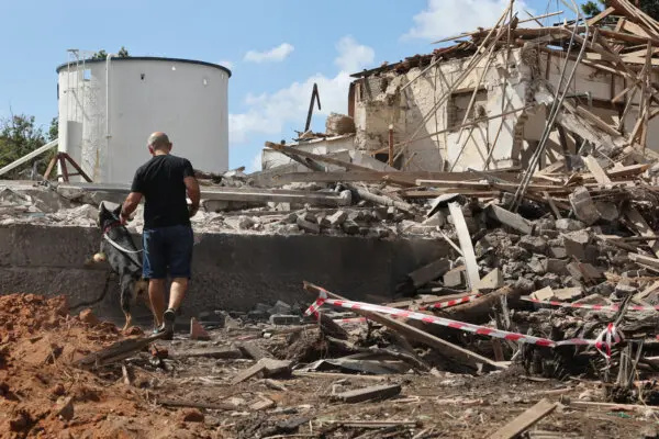 Un hombre y un perro revisan los escombros de un edificio destruido tras un ataque con misiles iraníes, en Hod HaSharon, Israel, el 2 de octubre de 2024. (Jack Guez/AFP vía Getty Images)