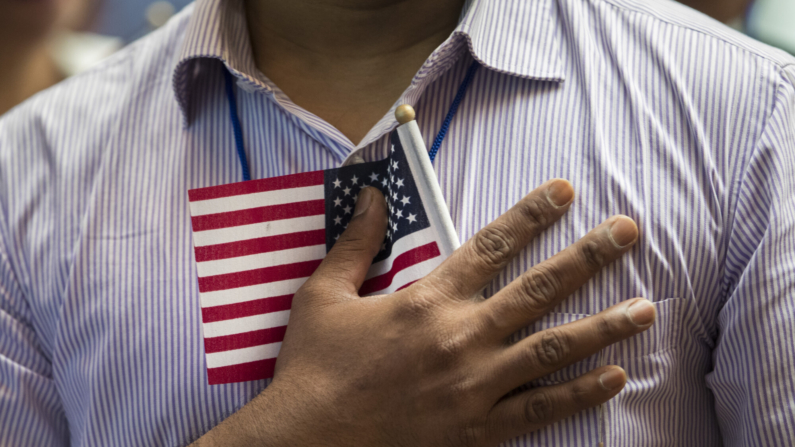 Un nuevo ciudadano estadounidense sostiene una bandera contra su pecho durante el Juramento de Lealtad en una ceremonia de naturalización en la Biblioteca Pública de Nueva York, el 3 de julio de 2018 en la ciudad de Nueva York. (Drew Angerer/Getty Images)