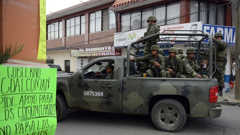 Soldados mexicanos patrullan las calles durante un operativo en busca de criminales en la zona denominada "Tierra Caliente" en la comunidad de Coalcoman, estado de Michoacán, México, el 21 de mayo de 2013. (Alfredo Estrella/AFP vía Getty Images)