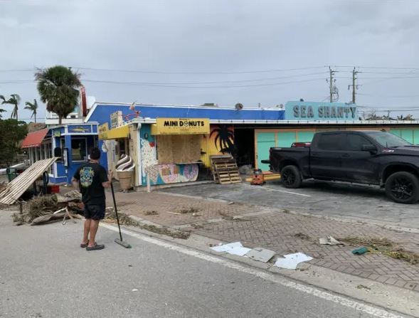 Anthony Pallaria (izquierda) frente a sus dos negocios en Siesta Key Village, Florida, el 11 de octubre de 2024. (T.J. Muscaro/The Epoch Times)