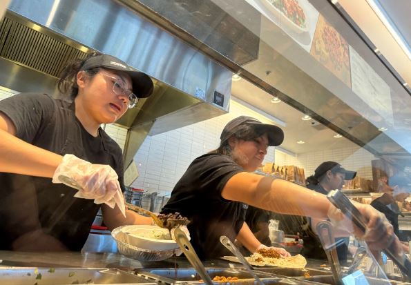 Trabajadores llenan pedidos de comida en un restaurante Chipotle en San Rafael, California, el 1 de abril de 2024. (Justin Sullivan/Getty Images)