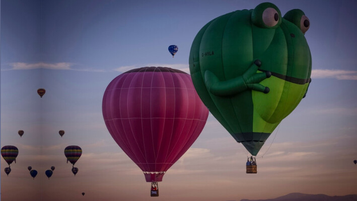 Globos navegan en el cielo capturados durante el vuelo en el globo aerostático Meow Wolf's Skyworm durante la Fiesta Internacional de Globos de Albuquerque en el Balloon Fiesta Park en Albuquerque, N.M., el 8 de octubre de 2024. (Chancey Bush/The Albuquerque Journal vía AP).