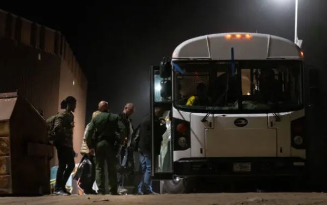 Los migrantes se preparan para ser transportados en autobús a instalaciones de procesamiento en Yuma, Arizona, el 18 de mayo de 2023. (John Fredricks/The Epoch Times)