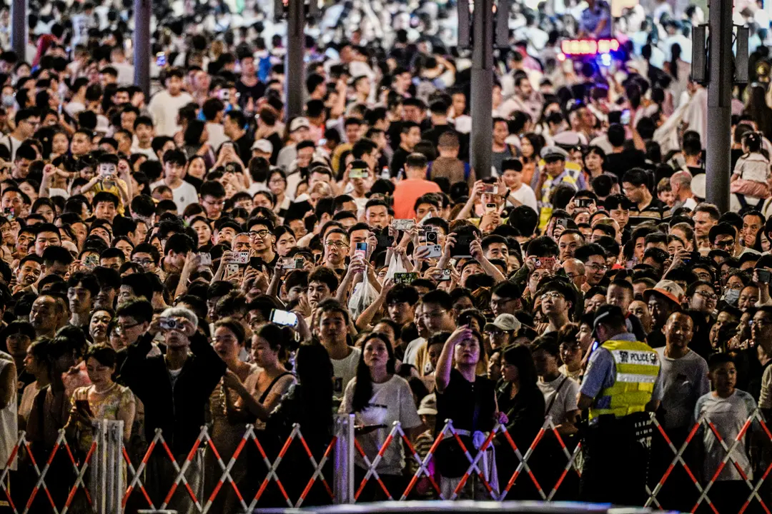 Varias personas caminan por una calle del paseo Bund de Shanghái el 19 de agosto de 2024. China se enfrenta a una serie de problemas como el envejecimiento y el descenso de la población y la espiral de la deuda, según Lewis. (Hector Retamal/AFP vía Getty Images)