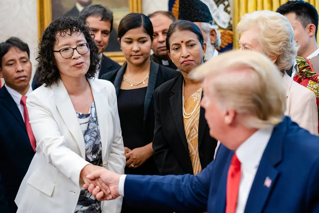 Yuhua Zhang, practicante de Falun Gong, habla con el presidente Donald Trump durante una reunión con sobrevivientes de persecución religiosa de 17 países, en la Oficina Oval el 17 de julio de 2019. (Shealah Craighead/Casa Blanca)