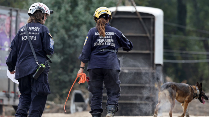 Miembros del Grupo de Trabajo de Búsqueda y Rescate Urbano de la FEMA buscan en una zona dañada por las inundaciones con un perro de búsqueda tras el paso del huracán Helene por el río Swannanoa el 4 de octubre de 2024 en Asheville, Carolina del Norte. (Mario Tama/Getty Images)