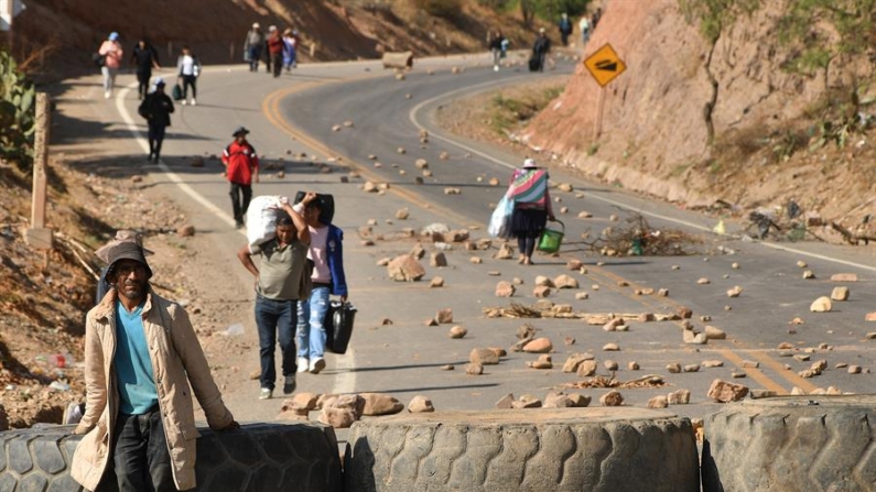 Personas caminan con sus equipajes durante la segunda jornada de bloqueos por seguidores del expresidente Evo Morales (2006-2019) el 15 de octubre de 2024, en Cochabamba (Bolivia). EFE/Jorge Ábrego