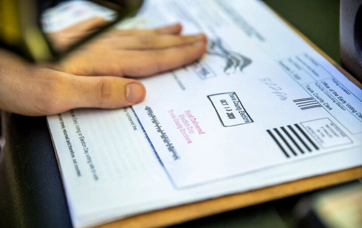 Un trabajador electoral sella la boleta de votación por correo de un votante en Austin, Texas, el 13 de octubre de 2020. (Sergio Flores/Getty Images)