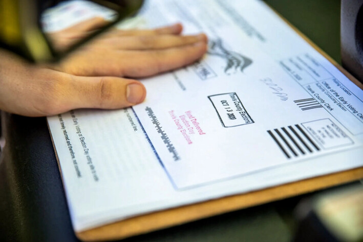 Un trabajador electoral sella la boleta de votación por correo de un votante en Austin, Texas, el 13 de octubre de 2020. (Sergio Flores/Getty Images)