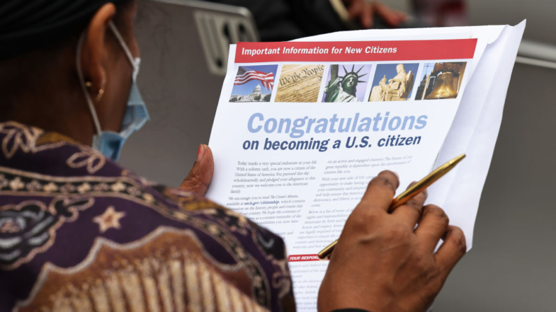 Una persona mira un paquete de bienvenida durante una ceremonia de naturalización en Damrosch Park, en el Lincoln Center for the Performing Arts de Nueva York, el 17 de septiembre de 2021. (Michael M. Santiago/Getty Images)