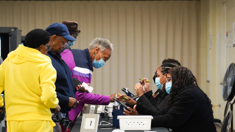 Varias personas se registran para emitir su voto el primer día de votación anticipada en la Iglesia Metodista Unida East Point First Mallalieu de Atlanta, el 15 de octubre de 2024. (Megan Varner/Getty Images)