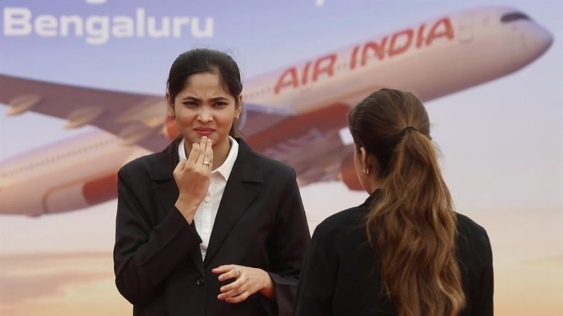 Miembros de Air India frente a la valla publicitaria de Air India durante la ceremonia inaugural de la construcción de la instalación de mantenimiento, reparación y revisión (MRO) de Air India en el Aeropuerto Internacional de Bangalore Limited (BIAL) en Bangalore, India, el 4 de septiembre de 2024. EFE/EPA/Jagadeesh Nv