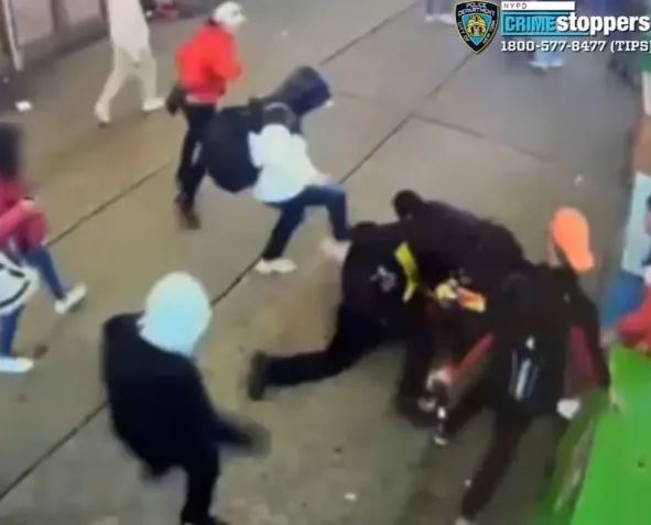 En una imagen de vídeo, un grupo de inmigrantes ilegales ataca a dos agentes del Departamento de Policía de Nueva York frente a un refugio cerca de Times Square, el 27 de enero de 2024. (Departamento de Policía de Nueva York)