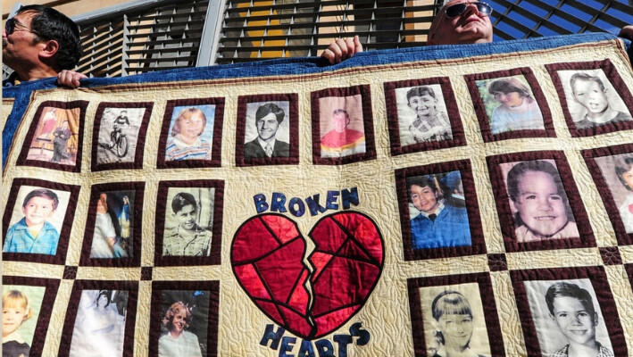 Jorgen Olsen (dcha.), víctima de abusos, y Glenn Gorospa (izq.), simpatizante suyo, sostienen colchas con retratos de niños maltratados mientras se reúnen frente a la Catedral de Nuestra Señora de los Ángeles en Los Ángeles, California, el 1 de febrero de 2013. (Frederic J. Brown/AFP vía Getty Images). 