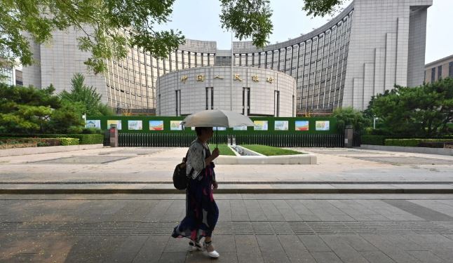 Una mujer pasa por delante de la sede del Banco Popular de China, el banco central del país, en Beijing el 9 de julio de 2024. (Adek Berry/AFP vía Getty Images)