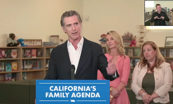 El gobernador de California, Gavin Newsom, destaca su programa para las familias del estado en una rueda de prensa en el condado de Sacramento, California, el 14 de agosto de 2023. Detrás de él está su esposa, Jennifer Siebel Newsom. (Gobernador de California Gavin Newsom vía YouTube/Screenshot vía The Epoch Times)