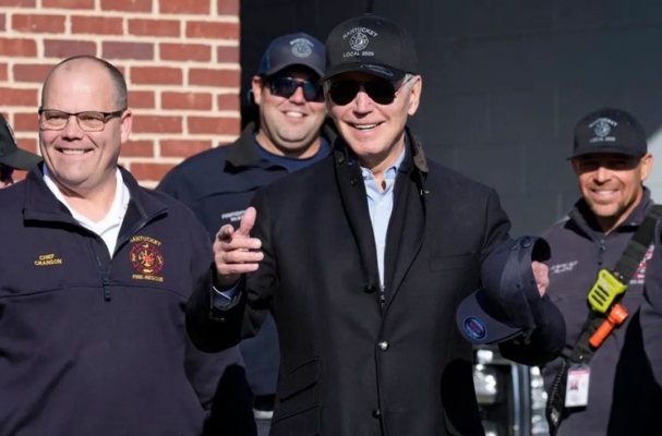 El presidente Joe Biden (C) junto al jefe del Departamento de Bomberos de Nantucket, Michael Cranson (L), habla durante una visita a los bomberos el Día de Acción de Gracias en Nantucket, Massachusetts, el 24 de noviembre de 2022. (Susan Walsh/Foto AP)