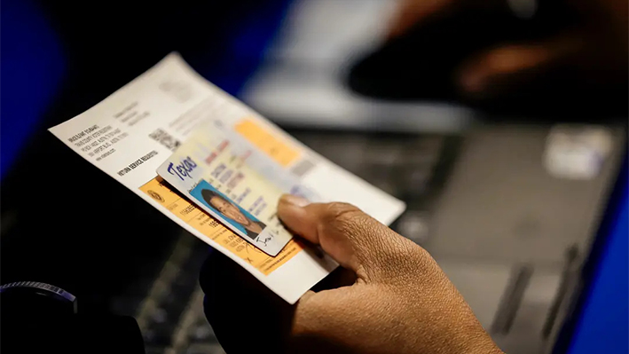 Un funcionario electoral comprueba la identificación con foto de un votante en un centro de votación anticipada en Austin, Texas, el 26 de febrero de 2014. (Eric Gay, Archivo/Foto AP)