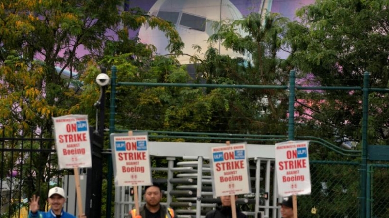 La imagen de un avión Boeing 737 detrás de trabajadores de la fábrica de Boeing y simpatizantes mientras se reúnen en una manifestación cerca de la entrada de una planta de producción de Boeing en Renton, Washington, el 15 de septiembre de 2024. (David Ryder/Reuters)