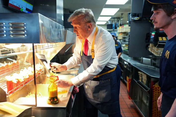 El expresidente Donald Trump trabaja detrás del mostrador preparando papas fritas durante una visita a un restaurante McDonald's, en Feasterville-Trevose, Pensilvania, el 20 de octubre de 2024. (Doug Mills-Pool/Getty Images)