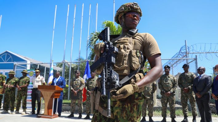 Un agente de policía de Kenia, que forma parte de una fuerza multinacional respaldada por la ONU, monta guardia en la pista durante una ceremonia de bienvenida a agentes de policía de Bahamas en el Aeropuerto Internacional Toussaint Louverture de Puerto Príncipe, Haití, el viernes 18 de octubre de 2024. (AP Photo/Odelyn Joseph)
