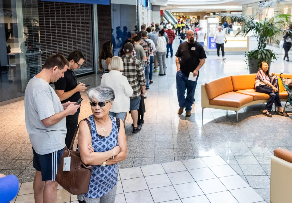 La gente espera en largas filas para depositar su voto en un centro comercial de Henderson, Nevada, el 19 de octubre de 2024. (John Fredricks/The Epoch Times)