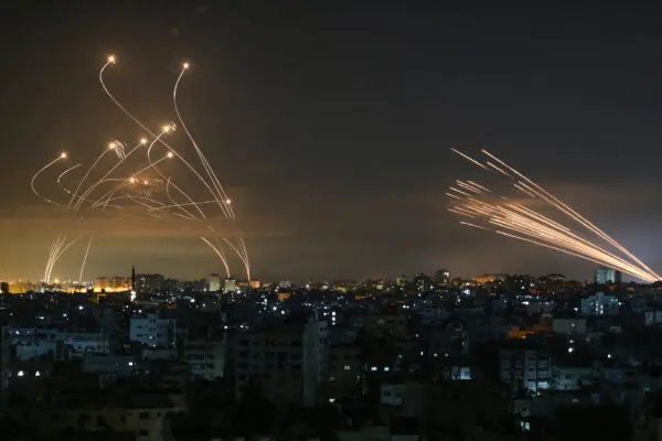 El sistema israelí de defensa antimisiles Cúpula de Hierro (izq.) intercepta cohetes (der.) disparados por Hamás hacia el sur de Israel desde Beit Lahia, en el norte de la Franja de Gaza, visto en el cielo de la Franja de Gaza durante la noche del 14 de mayo de 2021. (Anas Baba/AFP vía Getty Images)