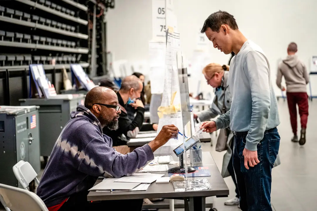 Un votante muestra su identificación con foto a los trabajadores electorales mientras llega para emitir su voto en las elecciones de mitad de periodo en la ciudad de Nueva York el 8 de noviembre de 2022. (Samira Bouaou/The Epoch Times)